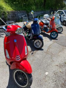 Various coloured Vespa scooters in a row