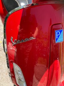 close up of Red Scooter and Vespa badge